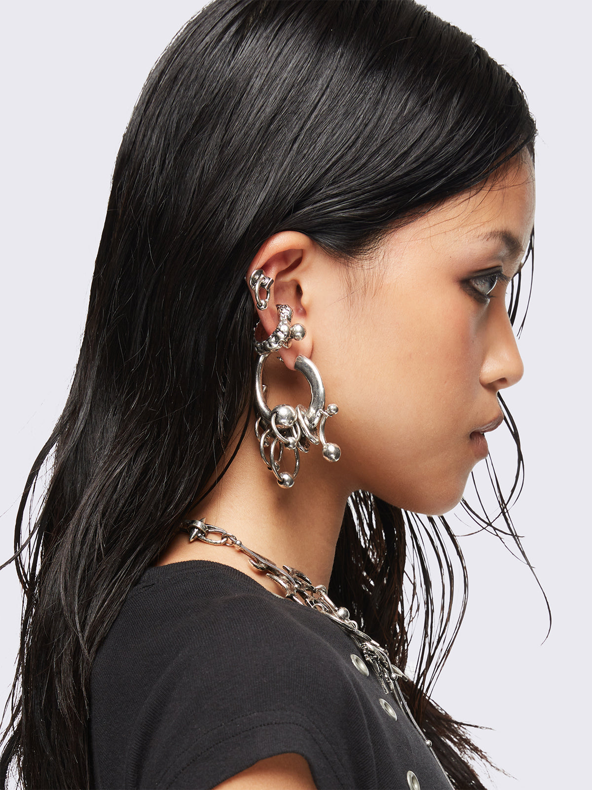 Silver 4-piece chunky earring set with hoops, studs, ear cuff, and layered ring and piercing details in an antique silver finish.
