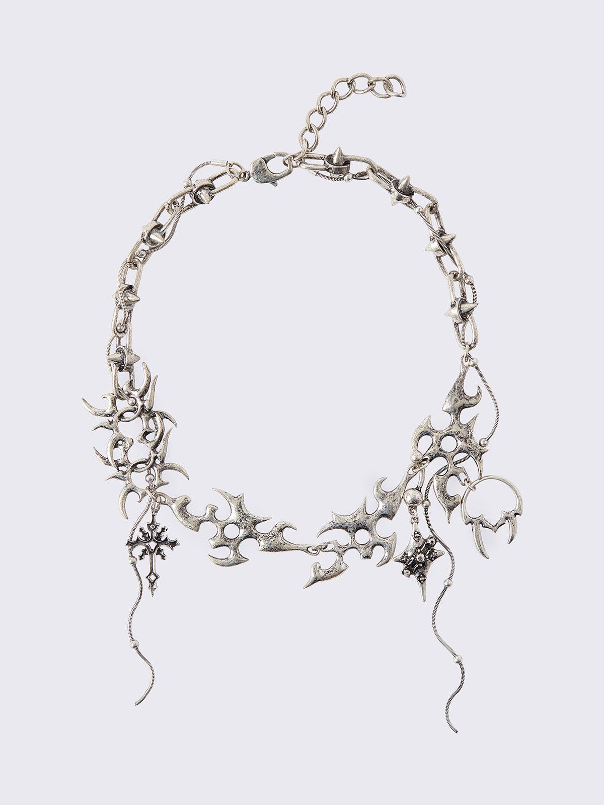 Chunky charm necklace with sigil-style details, cross charms and draped chain pendants.