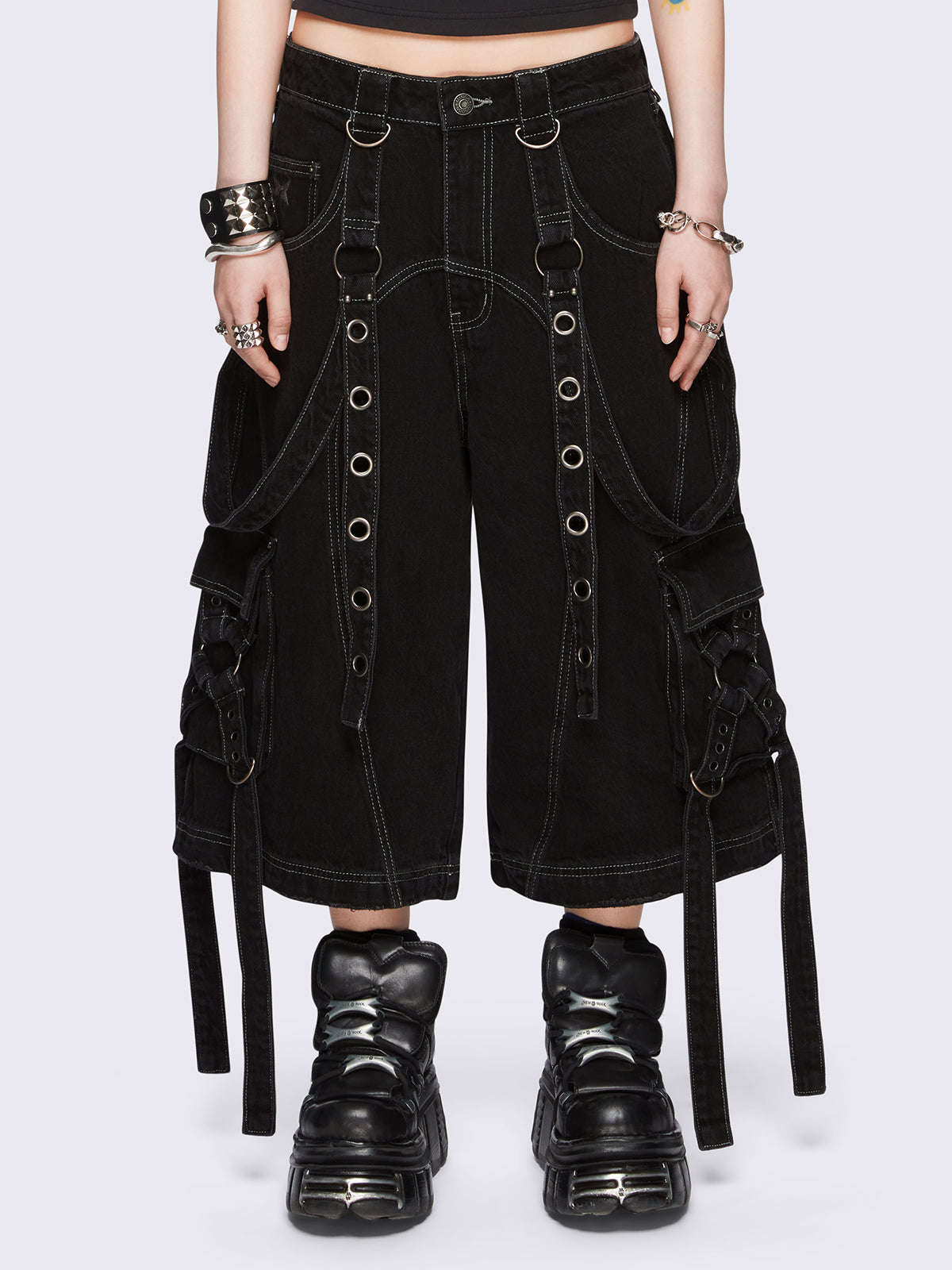 Black washed cargo jorts with multiple utility pockets, contrast white stitching, straps and metal hardware details.