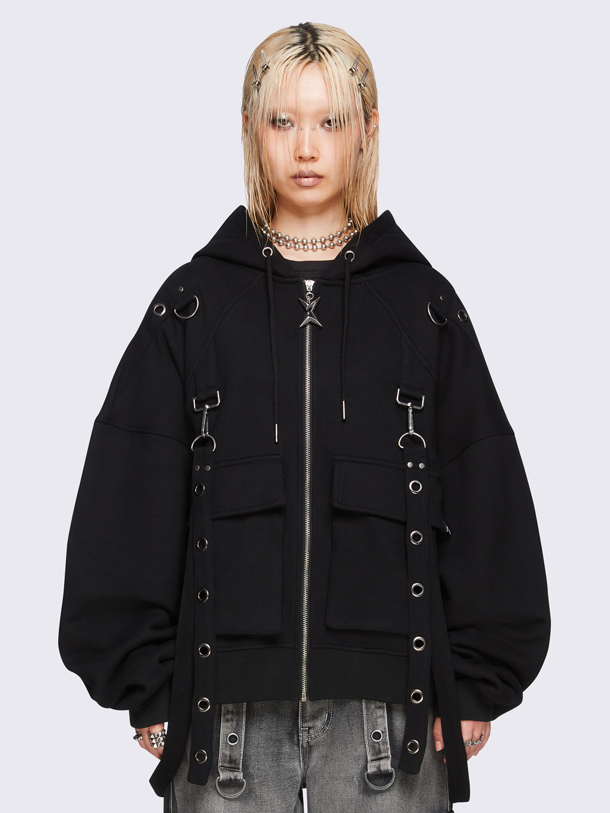 Black oversized zip-up hoodie jacket with straps, metal hardware, and flap pockets.