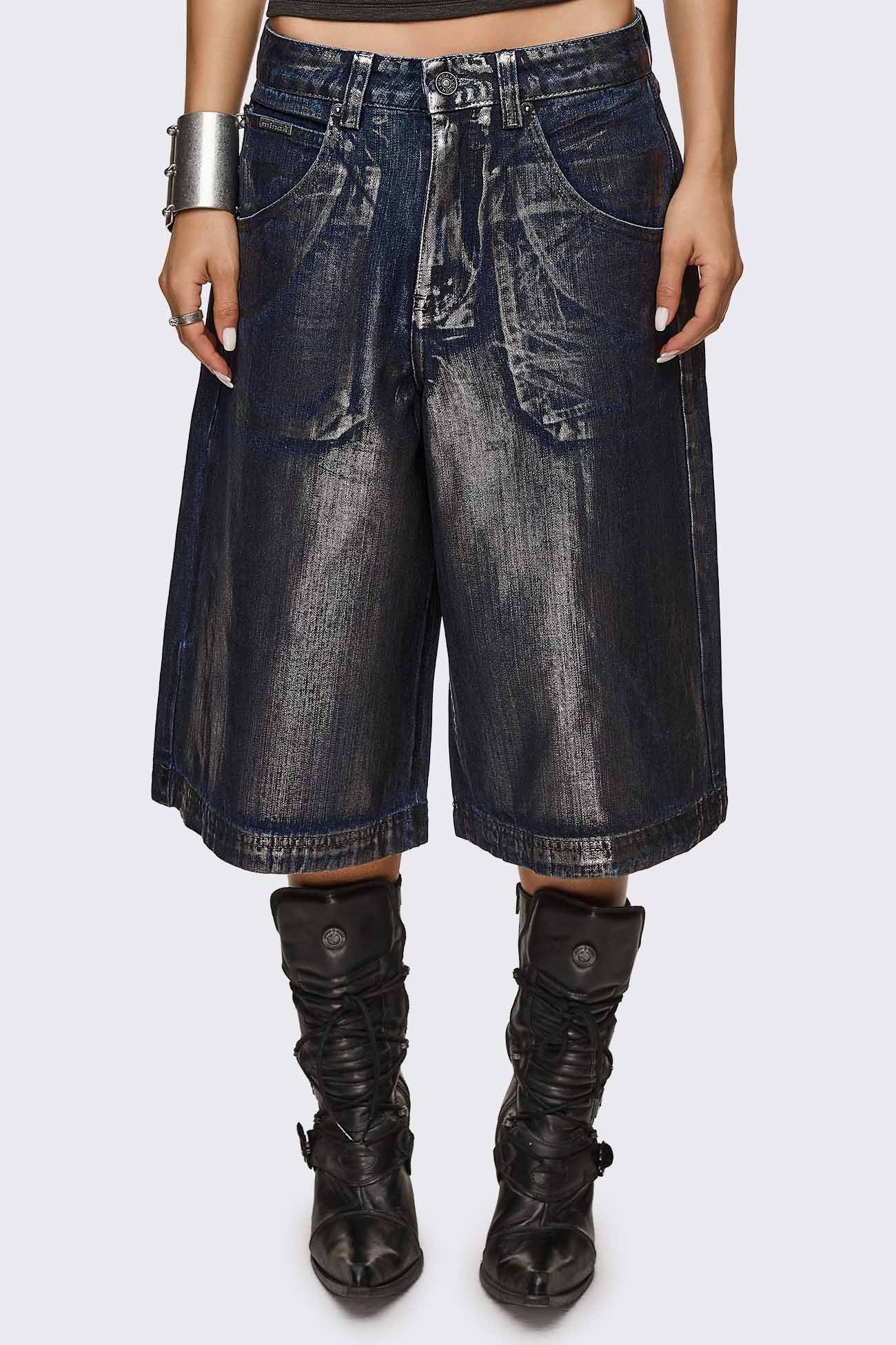 Longline jorts in dark blue coated denim with metallic finish and relaxed fit, in a grunge Y2K style.