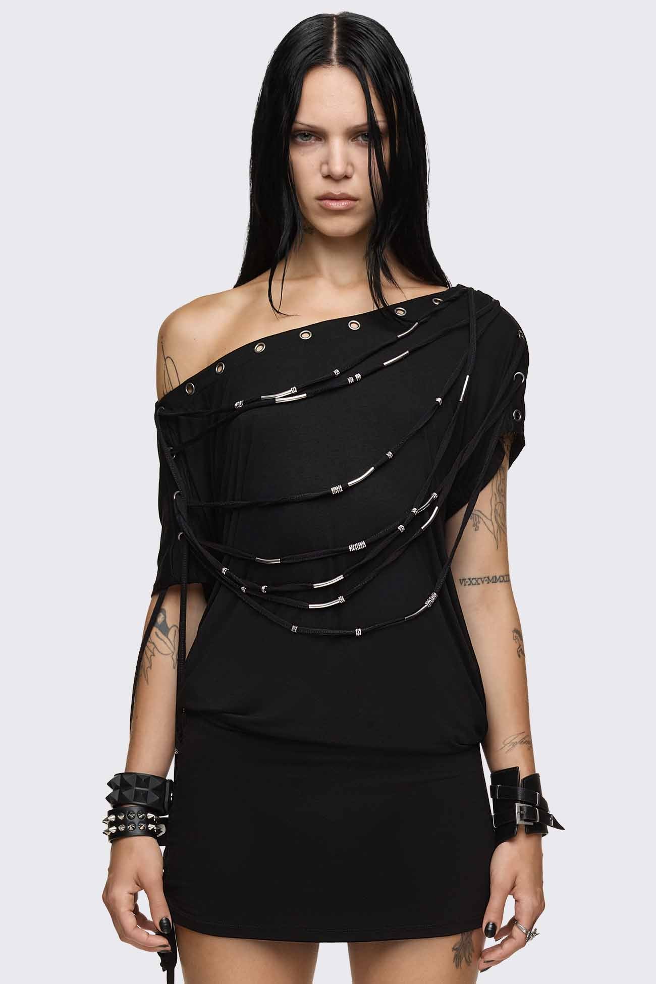 Black off shoulder mini dress with strappy silver hardware detail, eyelet neckline and side lace-up skirt.
