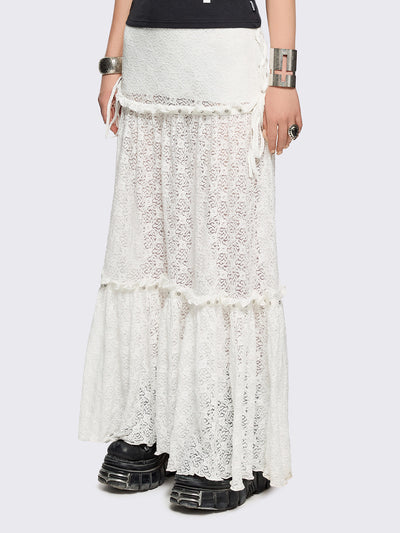 White floral lace maxi skirt with tiered lace layers with ruffles, lace-up sides with bow ties and eyelet trim details.