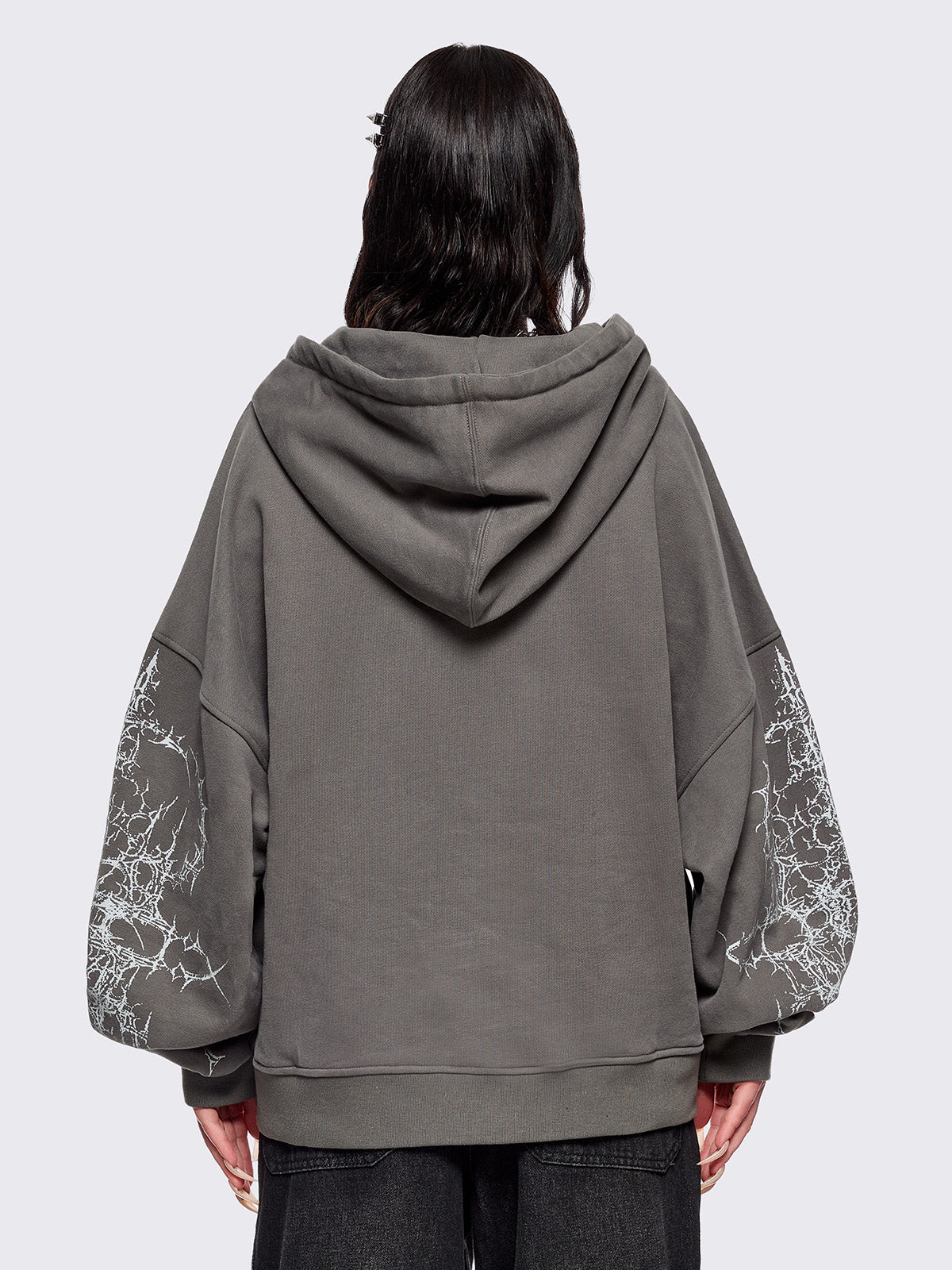 Grey zip up hoodie jacket featuring a sacred figure graphic on front and thorn sleeve prints.