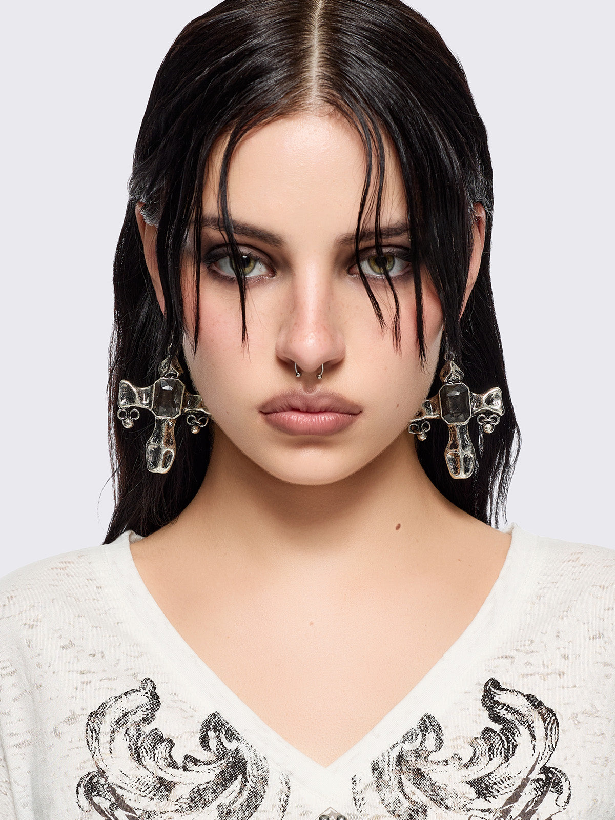 Silver dangle earrings with cross pendants featuring black stone details.