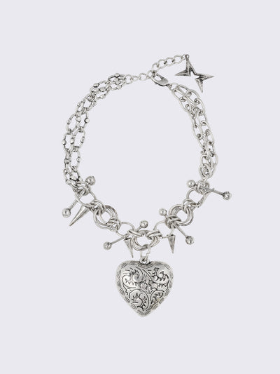 Silver chunky charm necklace with 3D heart pendant and bold metal piercing and spike details.