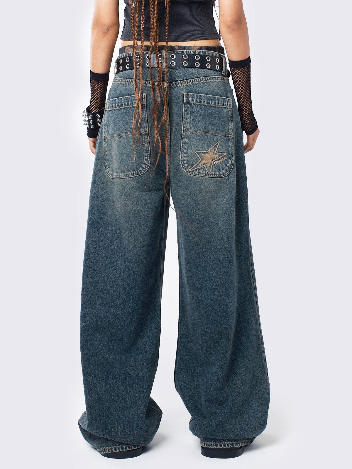 Baggy jeans in washed light blue with green overdye, Minga Star back embroidery, wide leg, regular waist, and relaxed fit. Y2K-inspired and grunge aesthetic.