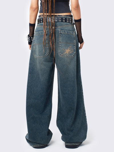 Baggy jeans in washed light blue with green overdye, Minga Star back embroidery, wide leg, regular waist, and relaxed fit. Y2K-inspired and grunge aesthetic.