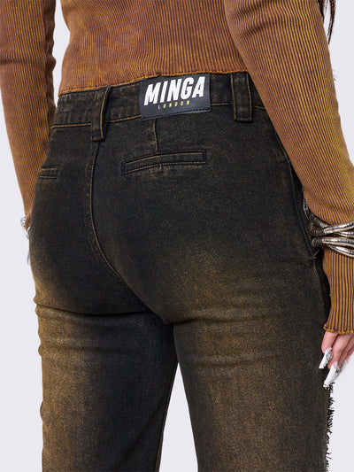 Black flared jeans featuring a honey overdye wash, a chunky buckle belt, distressed seams details and raw frayed hems. 