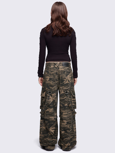 Camo multi pocket cargo jeans featuring a detachable-leg with zipper and all over straps and D-rings details.
