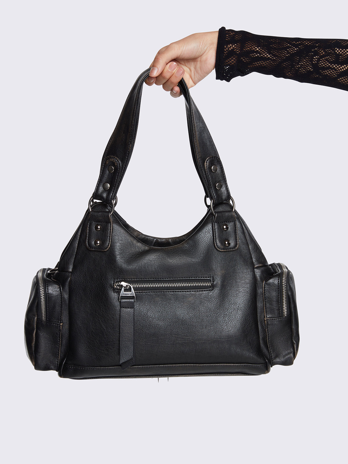 Black faux leather shoulder bag with silver chains, spike charms, side pockets, and embroidered cross detail on the front.
