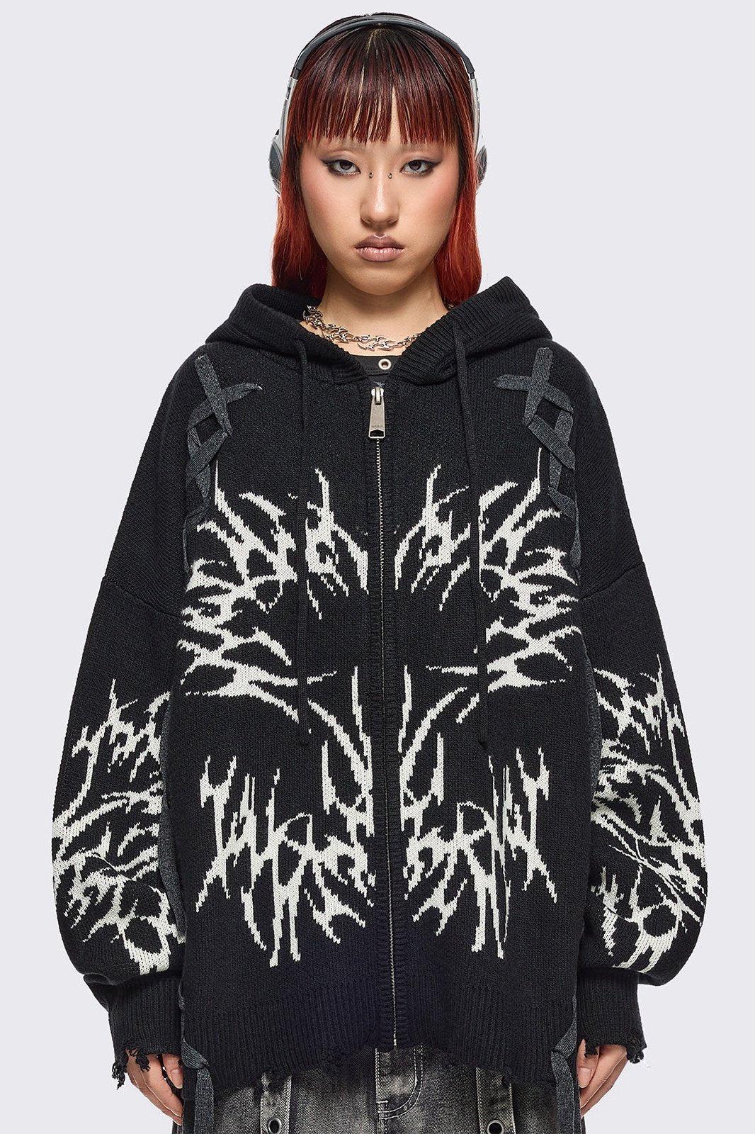 Black hooded chunky knit cardigan featuring white sigilism graphic design, contrast grey lace up details and distressed trims.