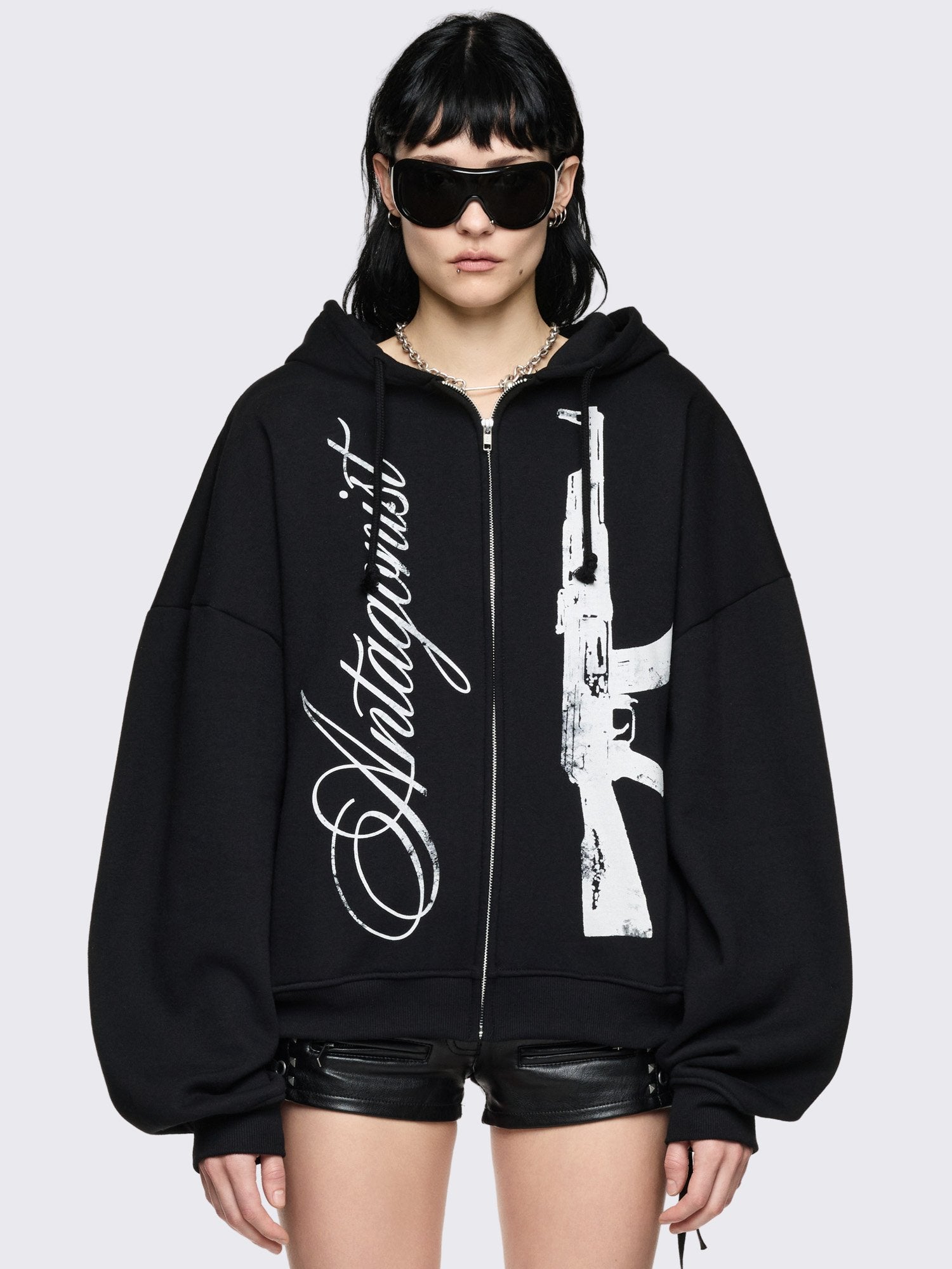 Black oversized zip up hoodie with "Antagonist" graphic front print.
