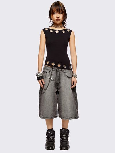 Black asymmetric top with chunky eyelets along neckline and hem and boat neckline.