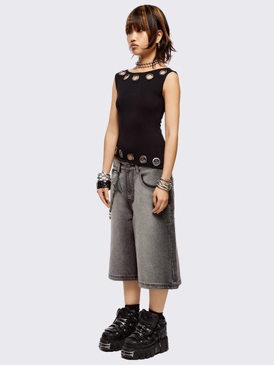 Black asymmetric top with chunky eyelets along neckline and hem and boat neckline.
