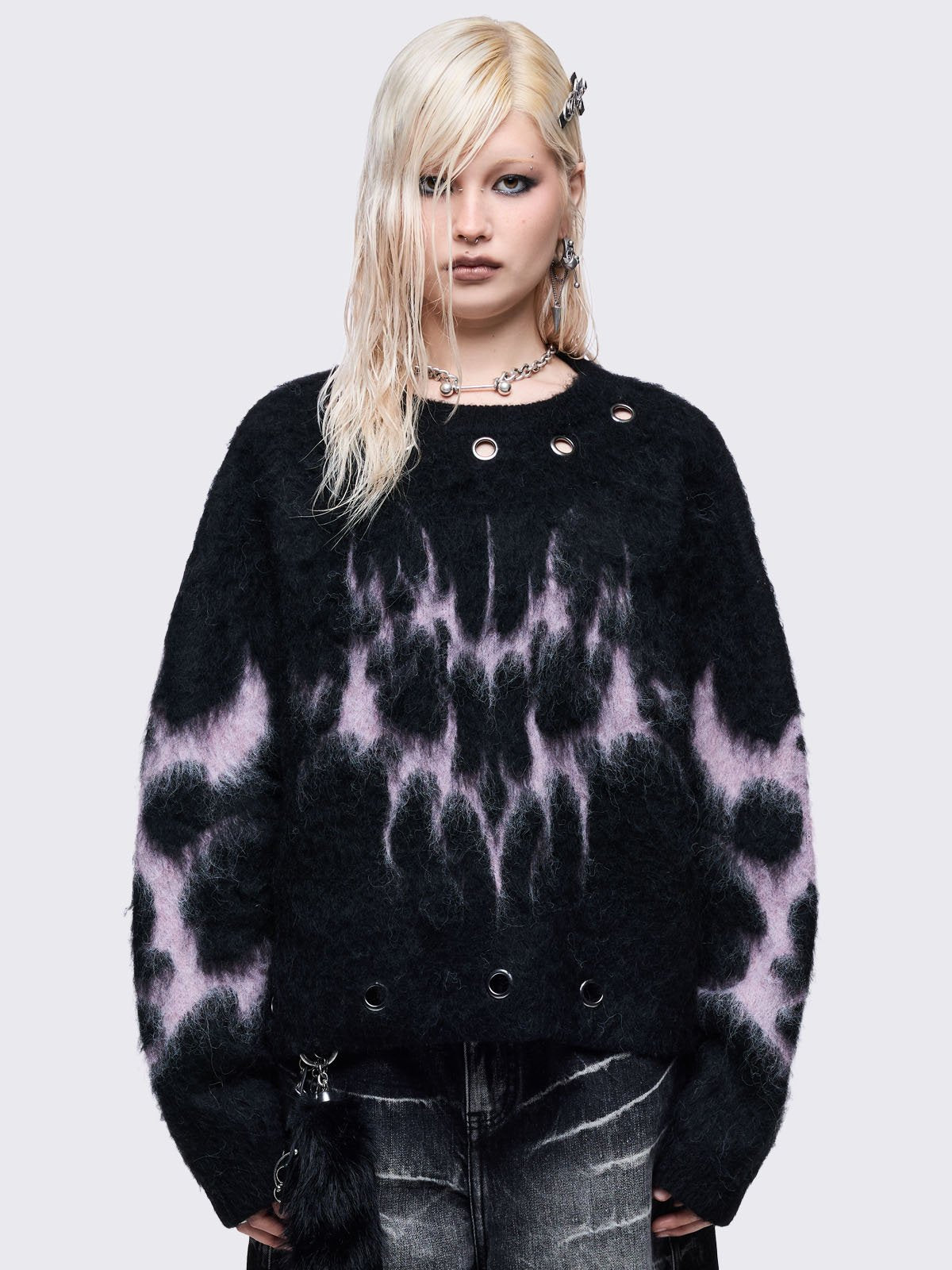 Black knitted jumper with pink sigil heart design and chunky silver eyelet details.