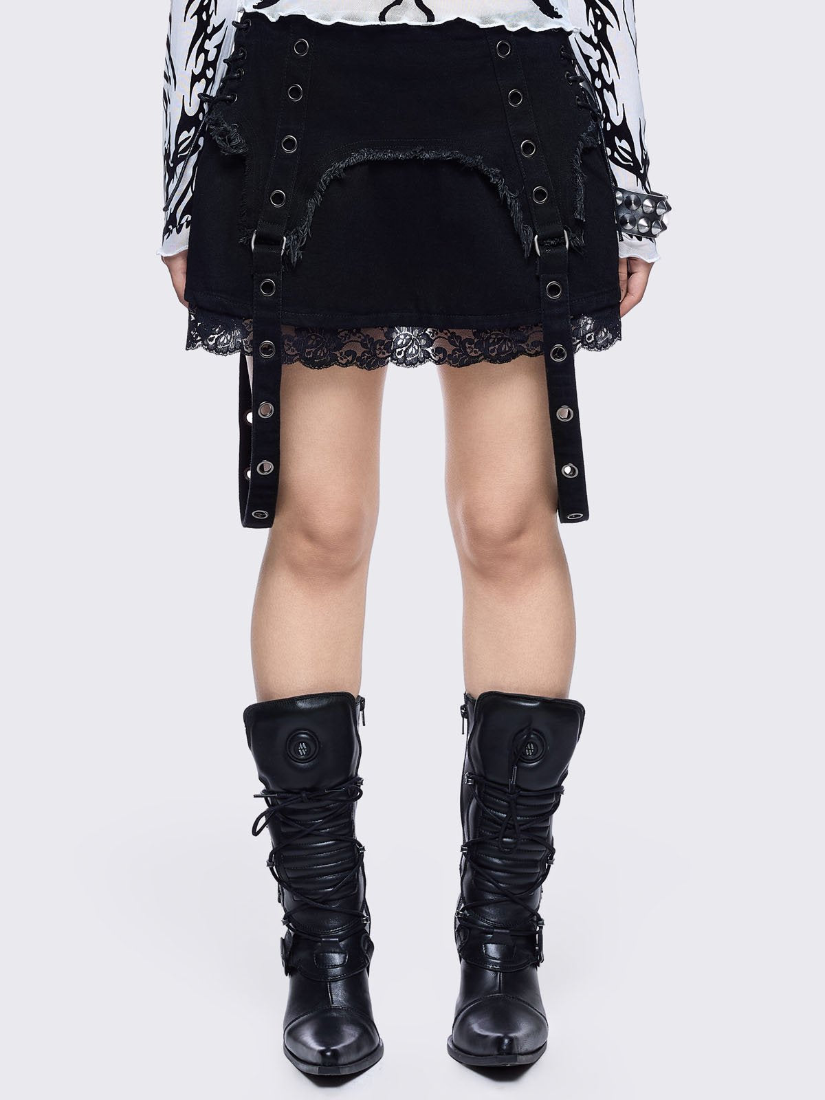 Black denim mini skirt with distressed frayed panels, lace up side details and eyelet straps.