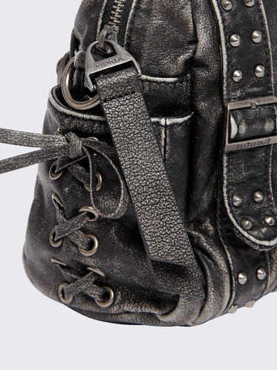 Black washed faux leather shoulder bag with multiple D-rings, buckles and hardware details, worn on shoulder with lace-up strap design.