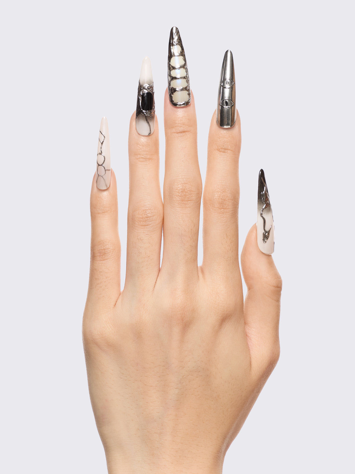 Press-on nail set in chrome and white with marble, piercing rings, chain lacing, and stiletto shape for a grunge glam look.