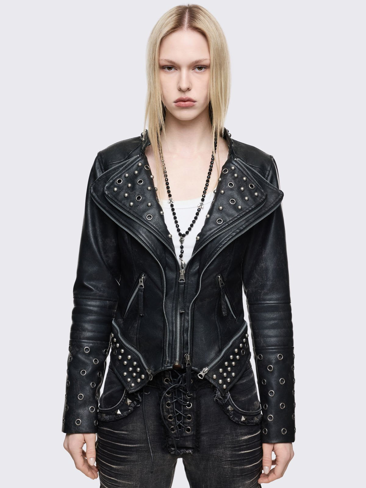 Black faux leather biker jacket with silver eyelet, stud and zip details. Pointed asymmetrical hem and large notched lapels.
