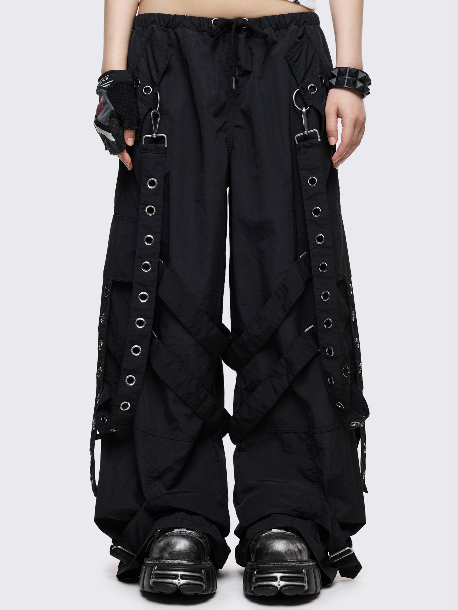 Black tech parachute cargo pants with all over straps, hardware details and utility pockets. 