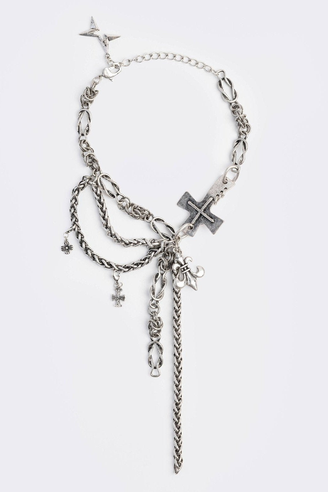 Layered necklace with chunky cross, fleur-de-lis and chain pendants.