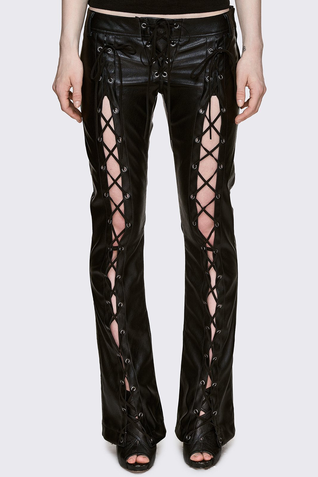 Black faux leather flared pants with lace-up cut-out legs and low-rise waist in a dark Y2K grunge style.