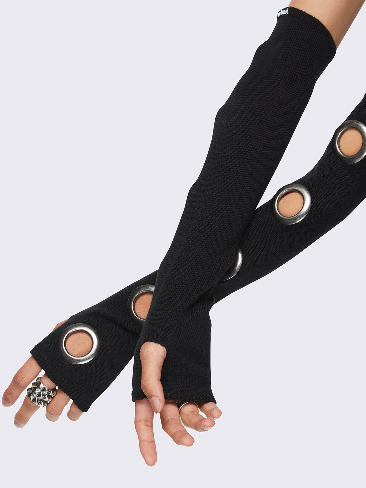 Black arm warmers with metallic hole details and thumbhole cuffs.