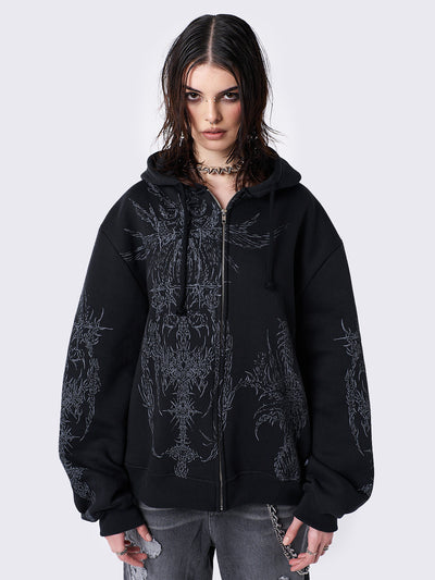 Oversized black zip-up hoodie with grunge graphic prints, drawstring hood, and ribbed trims. Y2K and acubi-inspired streetwear.