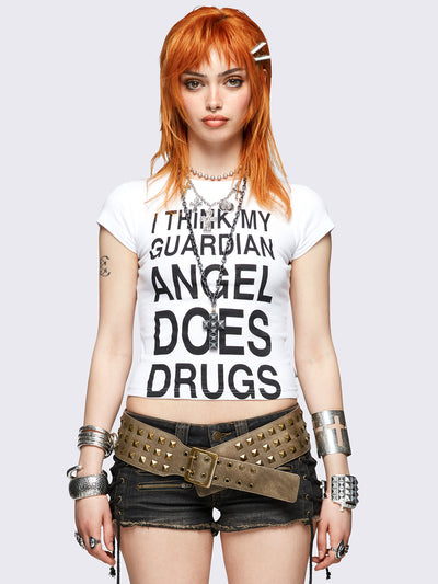White baby tee with bold black "I think my guardian angel does drugs" front print, featuring a black cross back print.