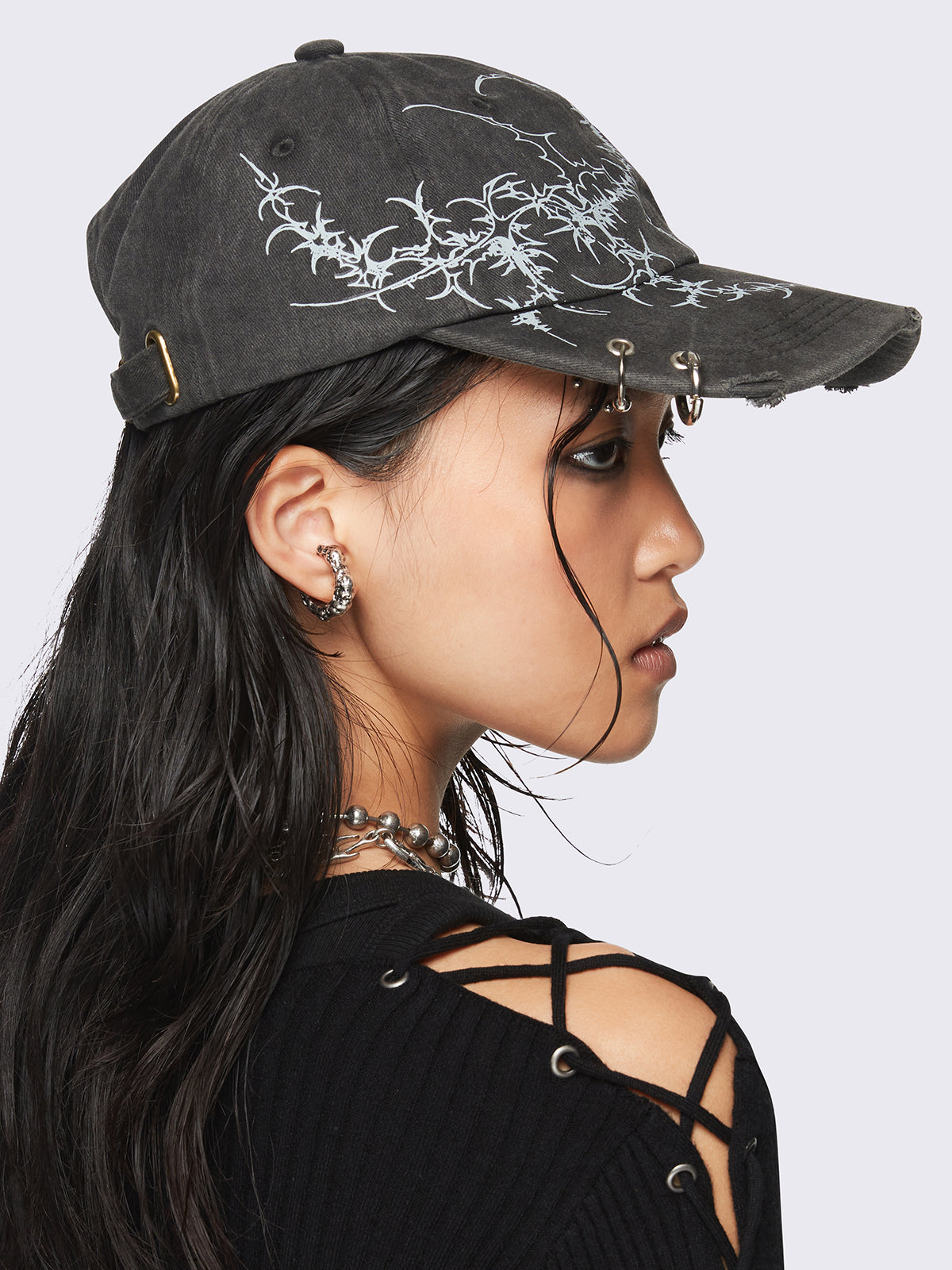 Black washed baseball cap with
Sigilism graphic print and distressed, eyelet and piercing details.