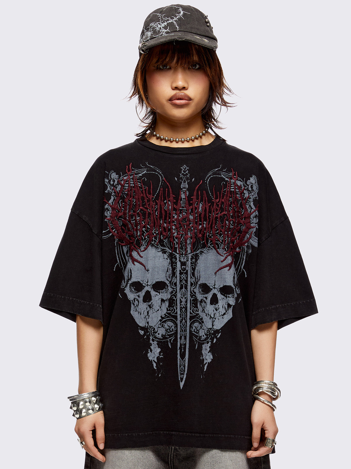 Black washed t-shirt with skulls and sword graphic front print and red embroidery.