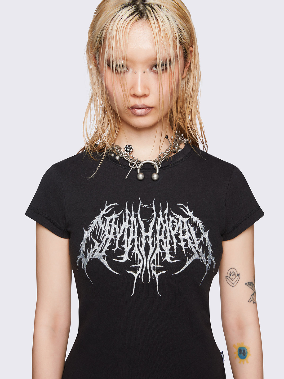 Black slim-fit baby tee with sigil-inspired front embroidery, short sleeves, and regular length.