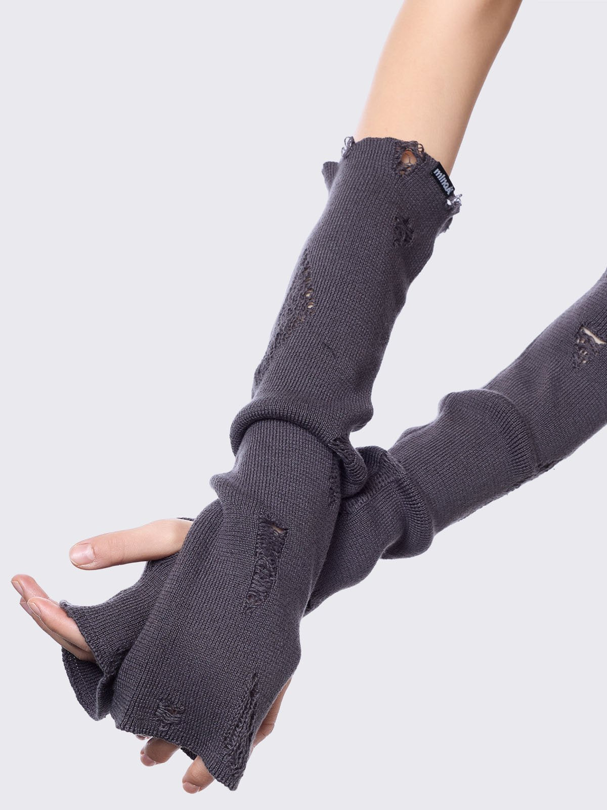 Grey knitted arm warmers with distressed details and thumbhole cuffs
