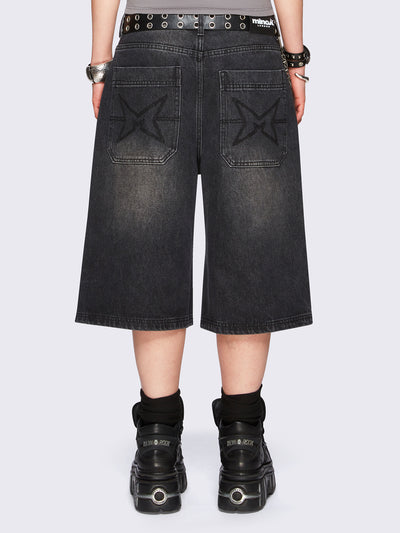 Black washed longline denim jorts with removable chain and wide-leg fit and knee-length cut.