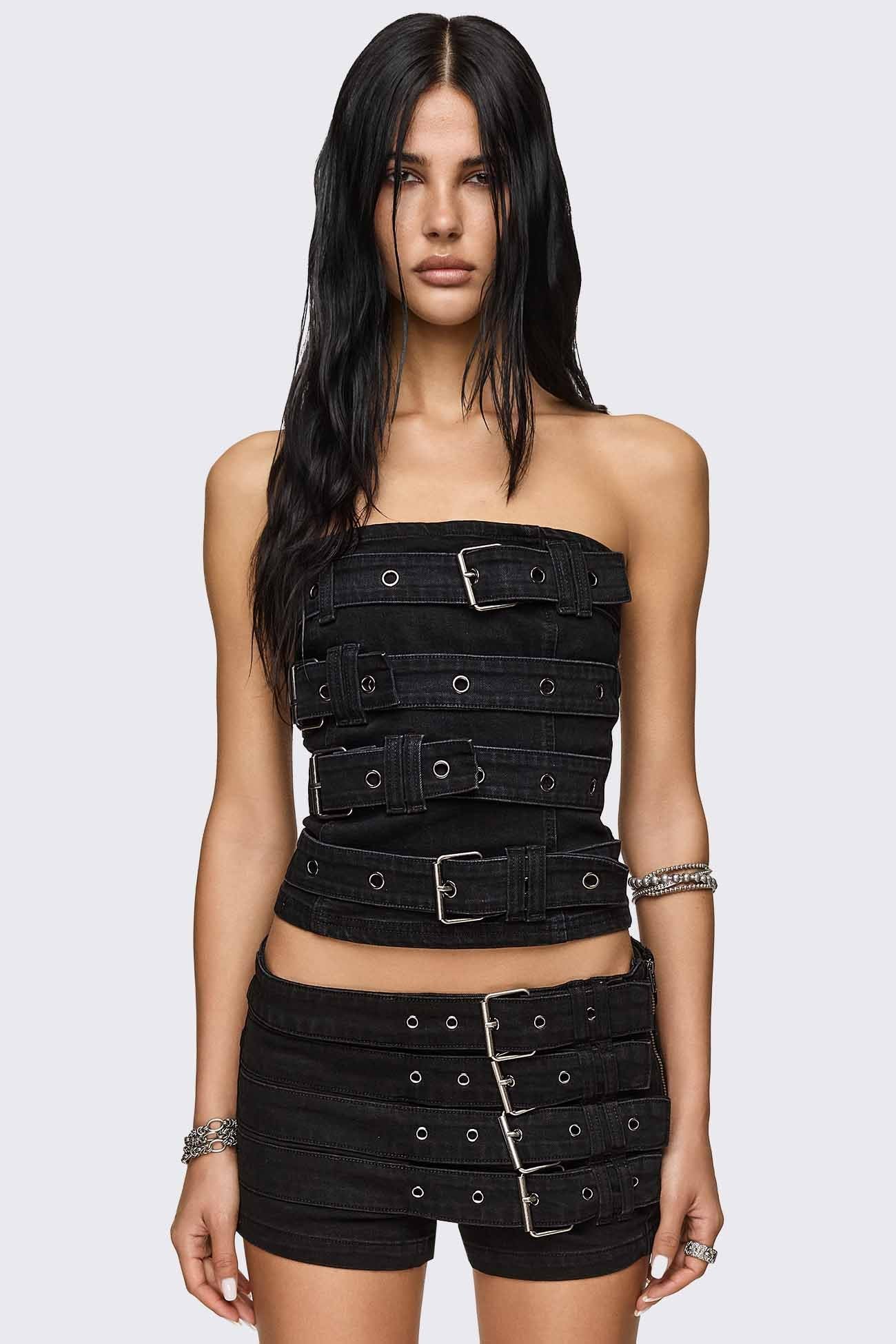 Black denim tube top with chunky buckle straps and silver eyelets, slim grunge silhouette.