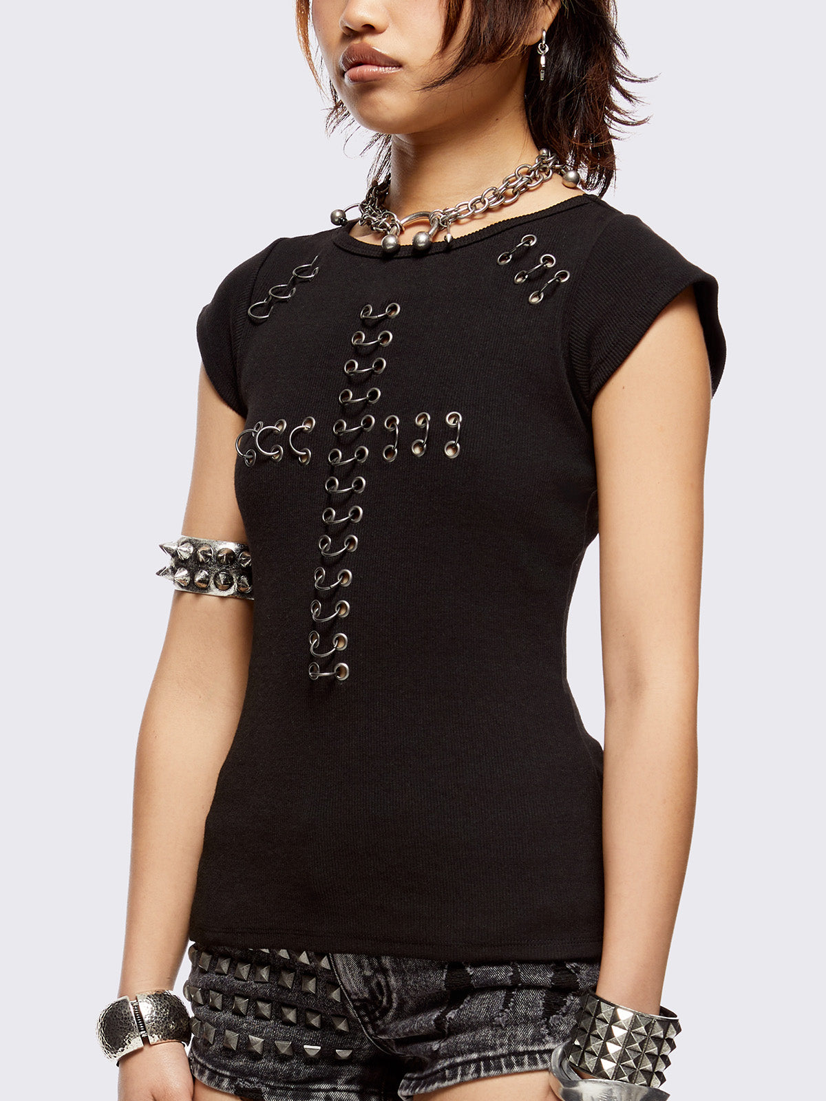 Black baby tee with pierced silver cross. Grunge goth vibes. 
