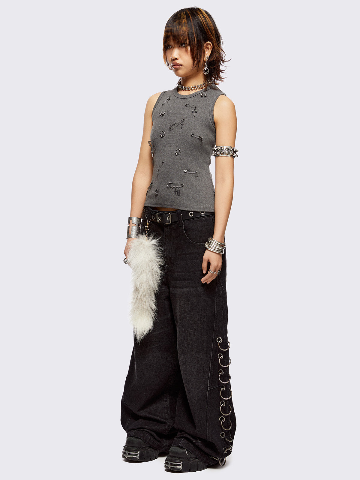 Sleeveless grey tank top with safety pins and piercing details. Grunge-style vibes. 