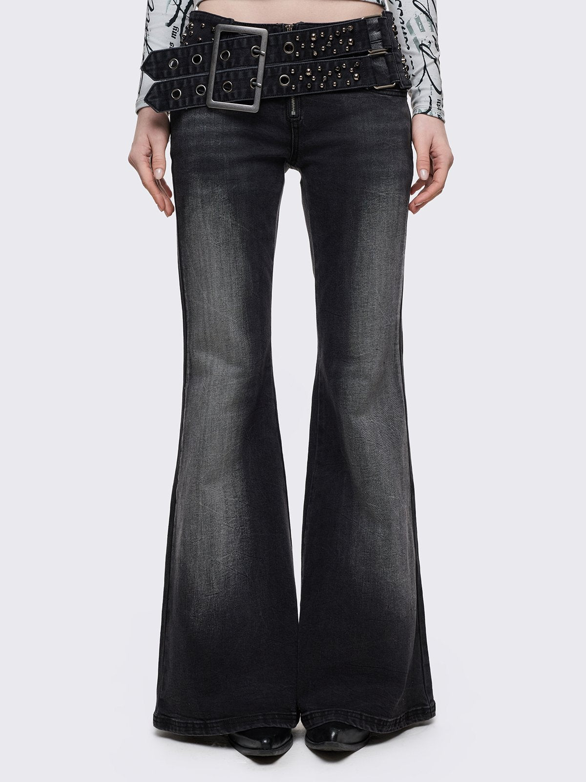 Grey washed flared jeans with double-buckle belt. 
