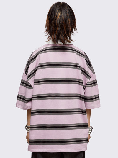 Pink rugby polo with black and grey stripes, white spread collar and a oversized fit.