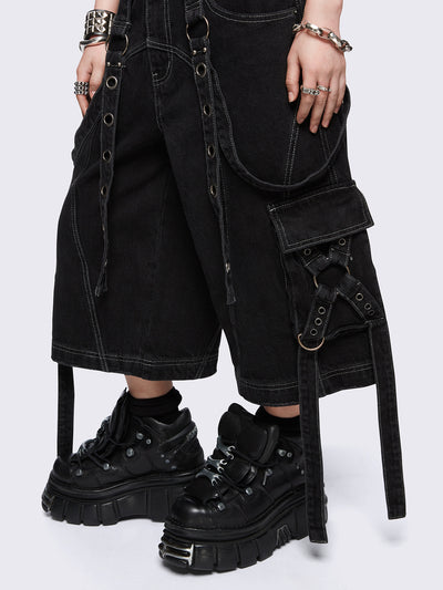 Black washed cargo jorts with multiple utility pockets, contrast white stitching, straps and metal hardware details.