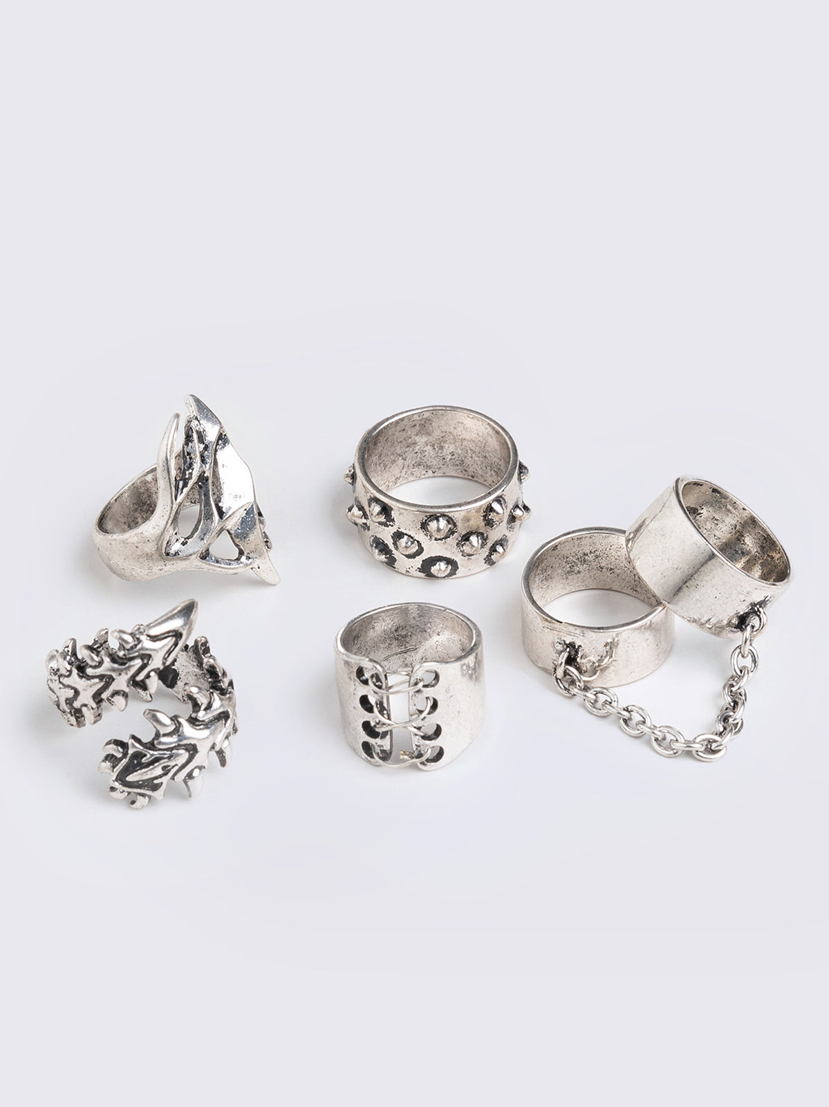 Set of 6 silver rings featuring a corset, spikes, thorns and chain designs. Slim and chunky bands styles. 